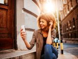 Picture of a young smiling woman using a phone